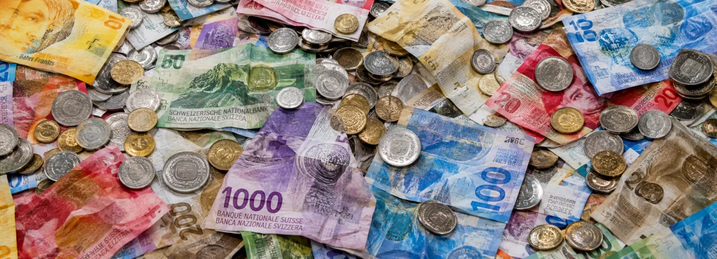 Das Bild zeigt einen Haufen von Schweizer Banknoten und Münzen.