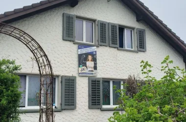 Das Bild zeigt ein Hausfassade mit einem Abstimmungsplakat, auf welchem für ein Ja zur Bildungsinitiative am 14. Juni geworben wird.