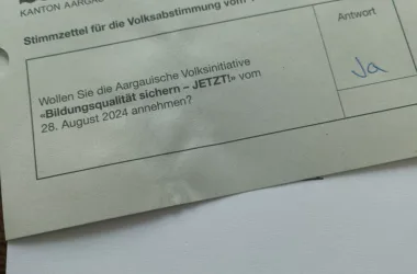 Das Bild zeigt einen Abstimmungszettel und einen Stimmrechtsausweis. Der Abstimmungszettel ist mit Ja beschriftet und der Stimmrechtsausweis unterschrieben.